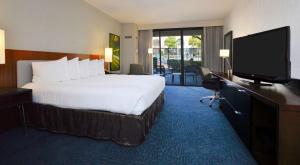 a hotel room with a bed and a flat screen tv at DoubleTree by Hilton Newark-Fremont in Newark