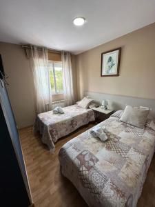 um quarto de hotel com duas camas e uma janela em Mirador De Rouris em Corunha