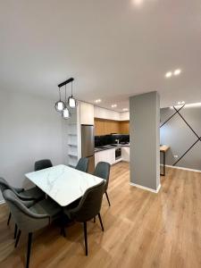 a dining room with a table and chairs and a kitchen at George apartments2023 in Korçë