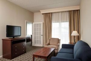 sala de estar con sofá azul y TV en DoubleTree Suites by Hilton Mount Laurel, en Mount Laurel