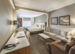 ナニュエットにあるDoubleTree by Hilton Nanuetのベッドとリビングルームが備わるホテルルームです。