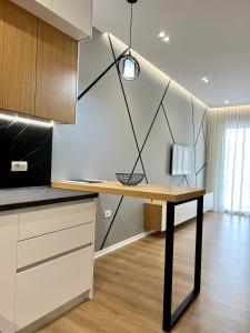 a kitchen with a wooden table in a room at George apartments2023 in Korçë