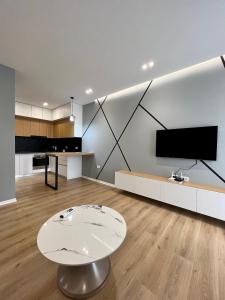 a living room with a table and a tv at George apartments2023 in Korçë