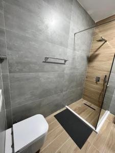 a bathroom with a shower and a toilet at George apartments2023 in Korçë