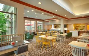 a restaurant with tables and chairs in a cafeteria at Hilton Garden Inn Salt Lake City/Sandy in Sandy