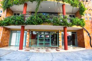 un edificio con columnas rojas y plantas en él en Hotel Santa Maria en Cancún