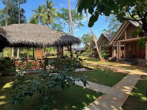 una casa con tetto di paglia e cortile di The Cottage Sigiriya a Sigiriya