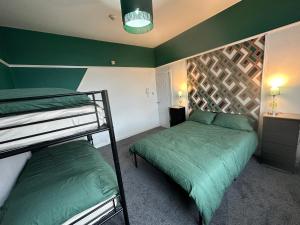 2 beliches num quarto com paredes verdes em Emerald Apartment Pleasure Beach Blackpool em Blackpool