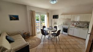 a kitchen and living room with a table and chairs at Apartments Gardelin Paklenica in Seline