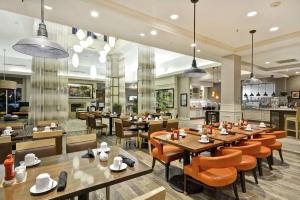 a restaurant with tables and chairs and a kitchen at Hilton Garden Inn Riverhead in Riverhead