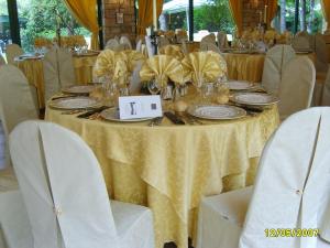 a table with a yellow table cloth and plates and chairs at Hotel Il Rustichello in Lonato del Garda