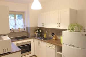 a kitchen with white cabinets and a white refrigerator at Monteurwohnung FeWo Shenas in Bremen