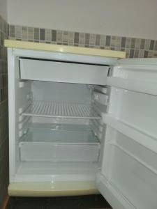 an empty refrigerator with its door open in a kitchen at complexe doha marjane tetouan in Tétouan