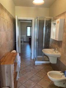 y baño con 2 lavabos y ducha. en Agriturismo La Mussia, en Castelnuovo
