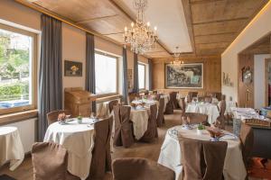 a restaurant with tables and chairs and a chandelier at Seeberg Garni Hotel in Caldaro