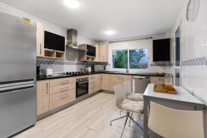 a kitchen with wooden cabinets and a white refrigerator at Townhouse with 3 bedrooms and sea views from the roof terrace in Torremolinos