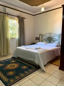 a bedroom with a bed and a window and a rug at Fênix Plaza Hotel in Aquidauana
