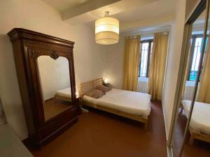 um quarto com uma cama com um espelho e um candeeiro em Chez Serge em Marselha