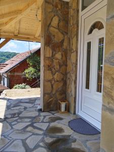 a door to a house with a stone walkway at Stari Hrast 1 in Prolomska Banja