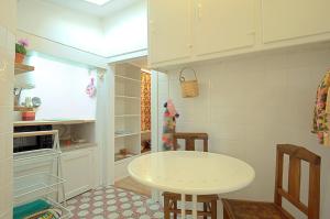 a small kitchen with a white table and a stove at Stay local in Alfama! Deolinda central Home, amazing view in Lisbon