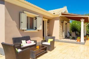 a patio with wicker chairs and a table at Villa Popi in Roda