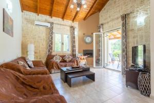 a living room with a couch and a table at Villa Popi in Roda