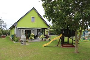 a green house with a slide and a playground at Auszeit im 8erland in Rankwitz