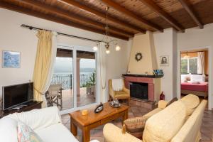 a living room with a couch and a fireplace at Villa Eleni in Agnítsini