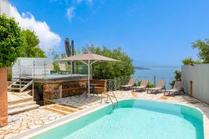 - une piscine avec une table et un parasol dans l'établissement Villa Anastasia, à Agnítsini
