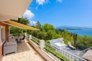 a house with a balcony with a view of the water at Villa Anastasia in Agnítsini