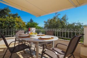 une table et des chaises sur une terrasse avec une clôture dans l'établissement Villa Anastasia, à Agnítsini