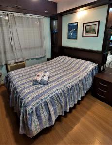 Un dormitorio con una cama con un par de zapatillas. en Apartamento Completo 2 Quartos Wi-Fi 300 Mbps, en Porto Alegre