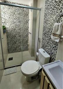 uma casa de banho com um chuveiro, um WC e um lavatório. em Apartamento Completo 2 Quartos Wi-Fi 300 Mbps em Porto Alegre