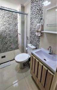 a bathroom with a toilet and a shower and a sink at Apartamento Completo 2 Quartos Wi-Fi 300 Mbps in Porto Alegre +52 photos