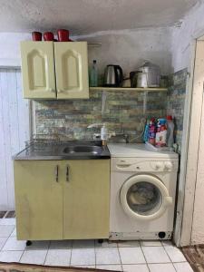 una cucina con lavatrice e lavandino di Joy apartment a Gradsko