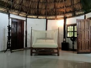 a chair in a room with a thatch roof at Finca Los Mangos in Palomino