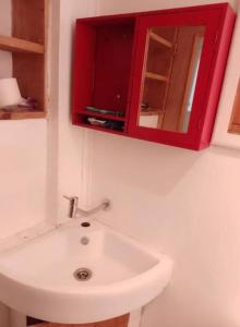 a bathroom with a red cabinet above a white sink at Casa en Valparaíso con vista al mar in Valparaíso
