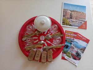 a red plate with cookies and a cup and spoons at Le Fontana in Nice