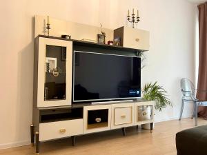 - un centre de divertissement avec une grande télévision dans le salon dans l'établissement Atria Urban Resort, à Bucarest