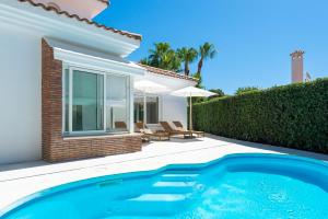 a villa with a swimming pool in front of a house at VB Higueron 4BDR Villa w Pool, Cinema & Ping pong in Benalmádena