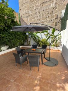 un tavolo e sedie sotto un ombrellone su un patio di Casa de Limon a Palma de Mallorca