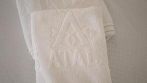 a white towel with the word akarma written on it at Hotel Atalayas Extremadura in Zafra