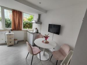 ein Wohnzimmer mit einem Tisch und Stühlen sowie eine Küche in der Unterkunft Zorić Apartments & Rooms 2 in Dubrovnik