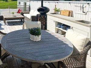einem Holztisch mit Topfpflanze auf einer Terrasse in der Unterkunft 6 person holiday home in STJ RNHOV in Stjärnhov