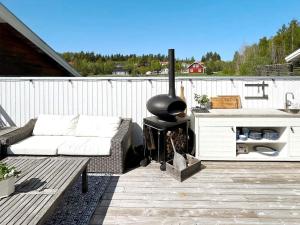 eine Terrasse mit einem Sofa und einem Kamin in der Unterkunft 6 person holiday home in STJ RNHOV in Stjärnhov