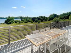 einen Holztisch und Stühle auf der Terrasse eines Hauses in der Unterkunft 6 person holiday home in STJ RNHOV in Stjärnhov