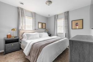 Schlafzimmer mit einem großen weißen Bett und einem Schreibtisch in der Unterkunft Exclusive NEW Listing! Maple Heights Charm in Maple Heights