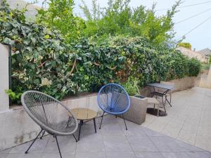 eine Gruppe von Stühlen und Tischen vor einer Hecke in der Unterkunft Zorić Apartments & Rooms 2 in Dubrovnik