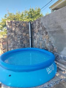 a blue swimming pool in front of a stone wall at House Villa Vito in Lopar