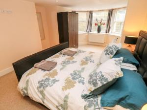 um quarto com uma cama com um cobertor e almofadas em Central 2 Bed Ground floor Appt em Buxton